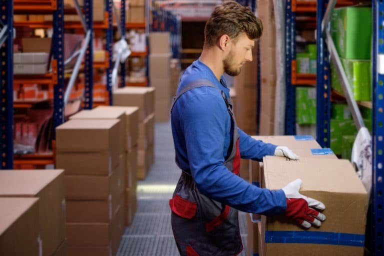 Porter carrying boxes in a warehouse